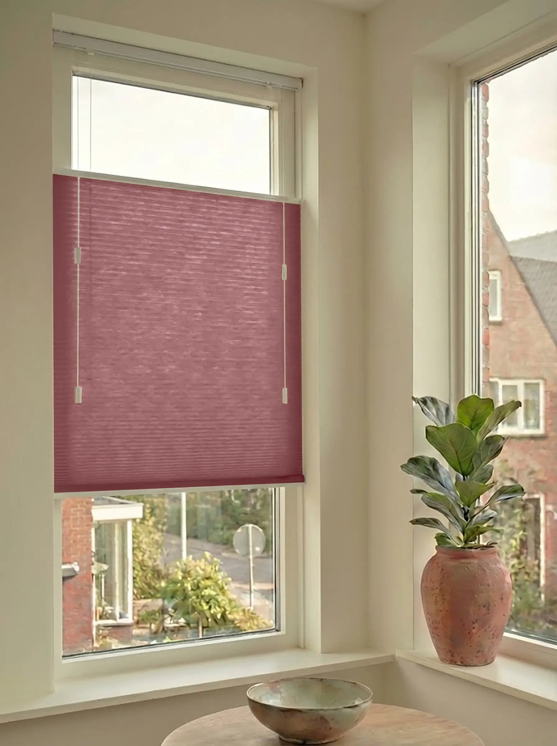 Lichtdoorlatend plisségordijn in Top Down Bottom Up uitvoering, gemonteerd in een licht interieur bij een raam met uitzicht.