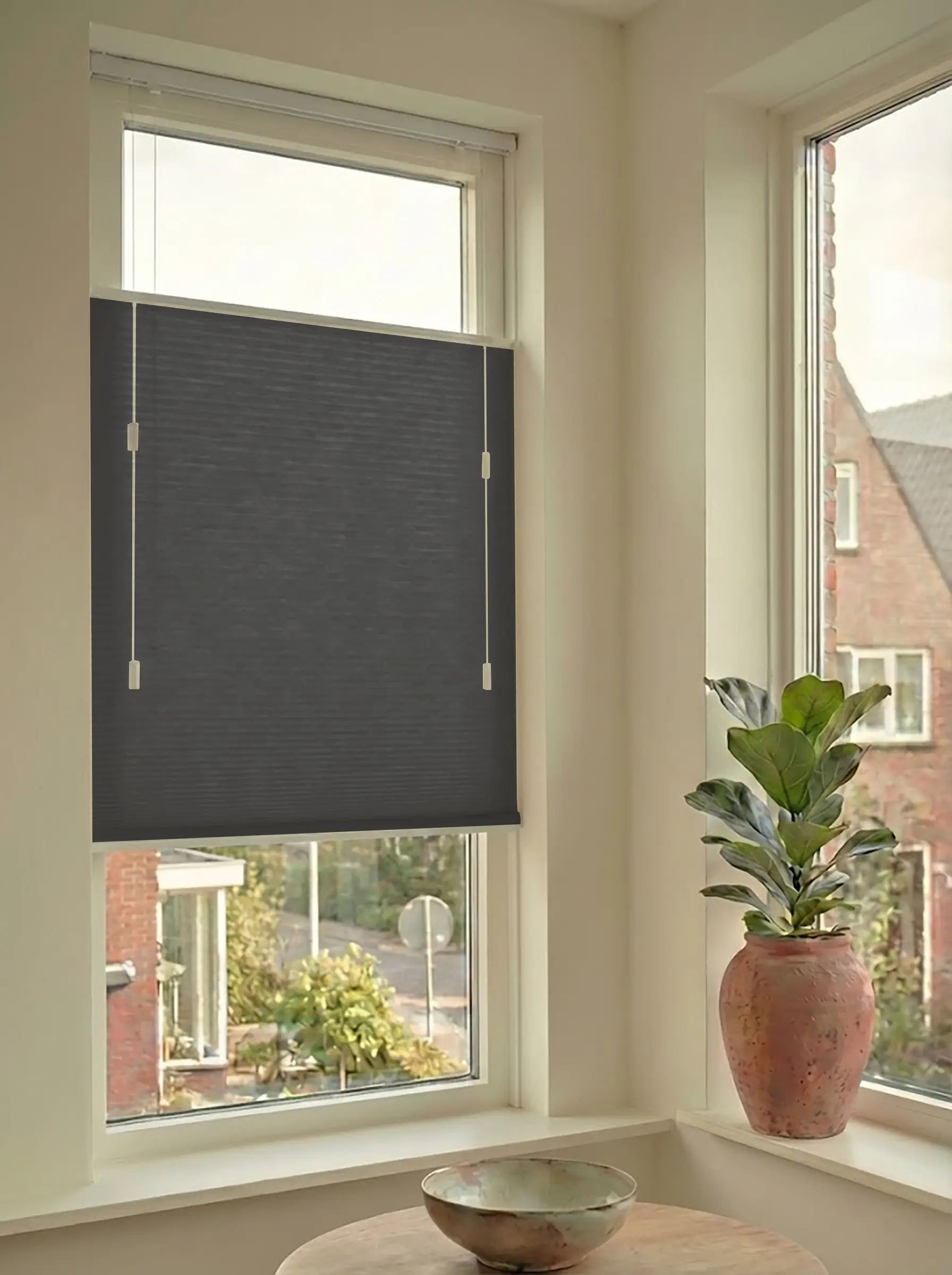 Lichtdoorlatend plisségordijn in Top Down Bottom Up uitvoering, gemonteerd in een licht interieur bij een raam met uitzicht.