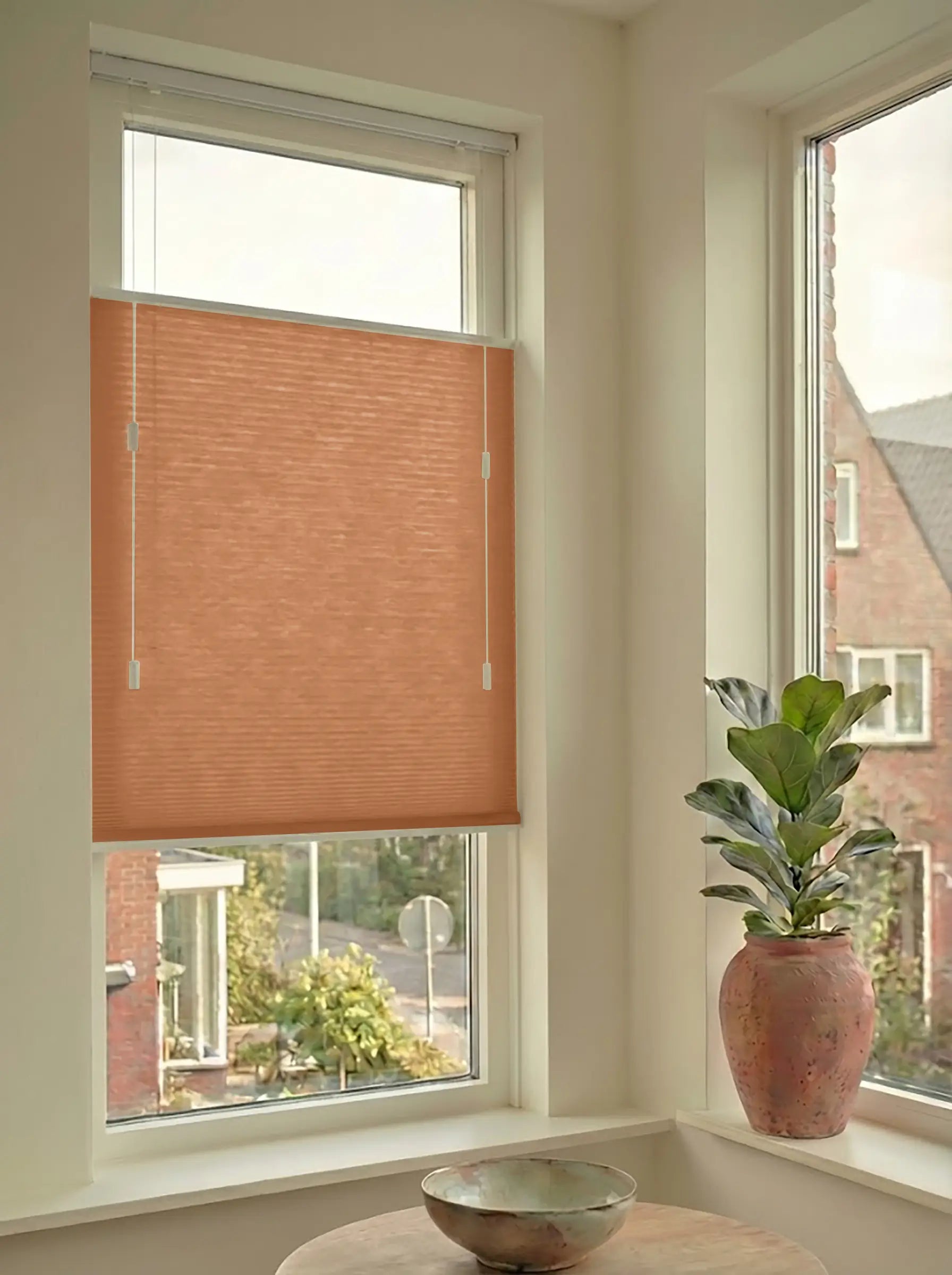 Lichtdoorlatend plisségordijn in Top Down Bottom Up uitvoering, gemonteerd in een licht interieur bij een raam met uitzicht.