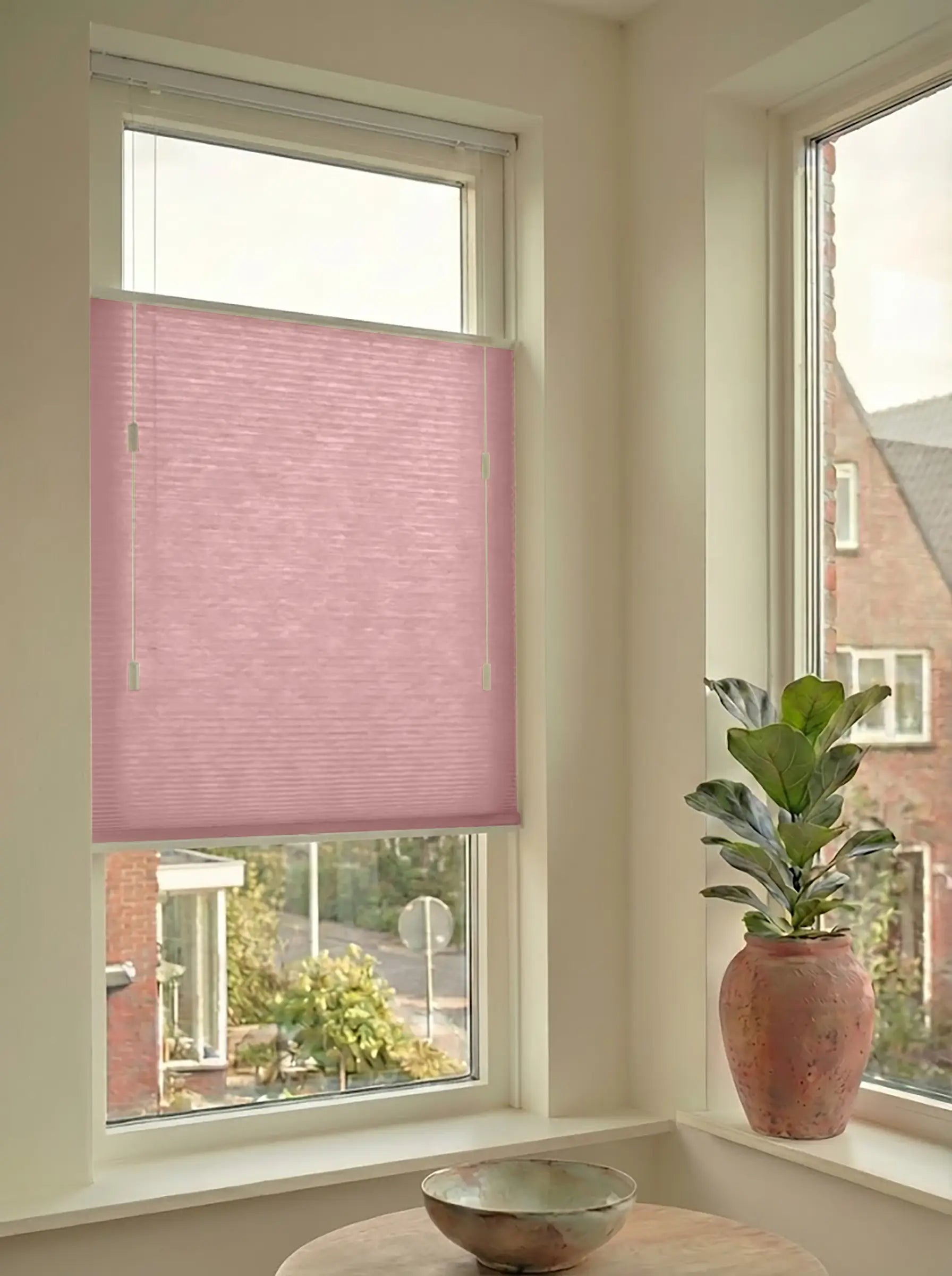 Lichtdoorlatend plisségordijn in Top Down Bottom Up uitvoering, gemonteerd in een licht interieur bij een raam met uitzicht.